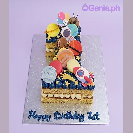 Blue number 1 shaped cake for a first birthday with space theme decorations including an astronaut, rocket, and planets Blue number 1 shaped cake for a first birthday with space theme decorations including an astronaut, rocket, and planets