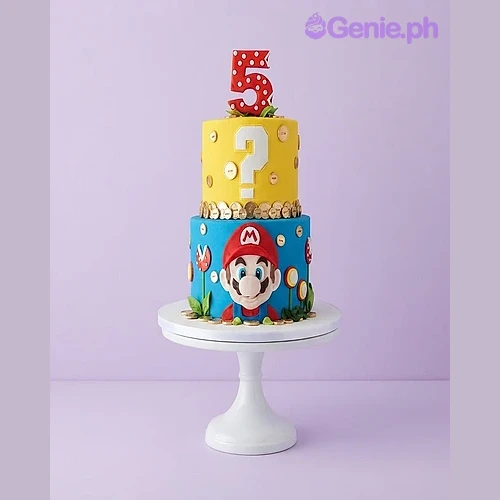 Super Mario-Inspired 2-Tier Cake Two-tier Super Mario fondant cake with a yellow top tier, blue bottom tier, Mario face cutout, and a large number 5 topper.