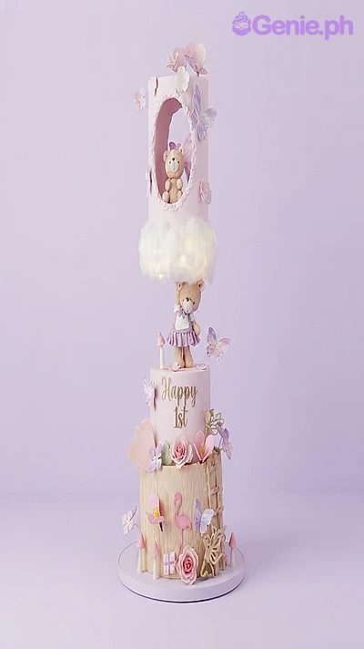 Teddy Bear 3-Tier Cake Pink 3-tier fondant cake with a teddy bear theme, featuring a hanging bear figurine, a cloud topper, and wood-textured bottom tier