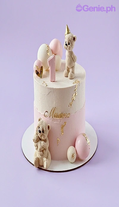 Teddy Bear White Birthday Cake A pink and white 1-tier Teddy Bear cake, featuring two hand-sculpted teddy bears, a pink number one, and gold leaf accents.