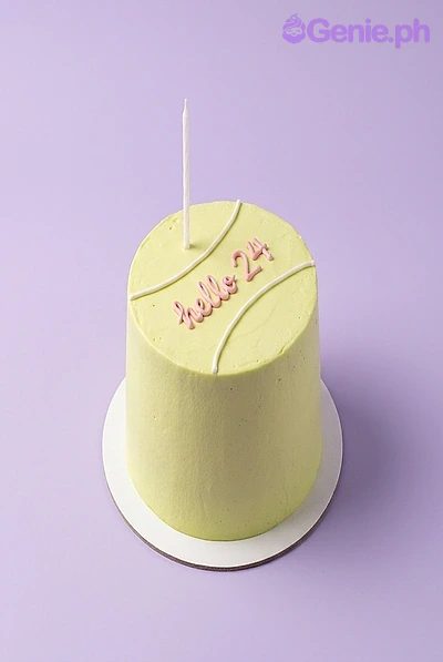Tennis Birthday Mint Cake A light green 1-tier cake themed around Tennis Birthday, featuring a white taper candle and white piped tennis ball lines with pink text.