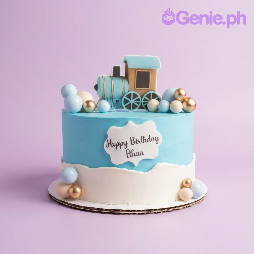 Train Birthday Cake A light blue and white 1-tier Train cake, featuring a blue steam engine topper, decorative spheres, and 'Happy Birthday Ethan' text.