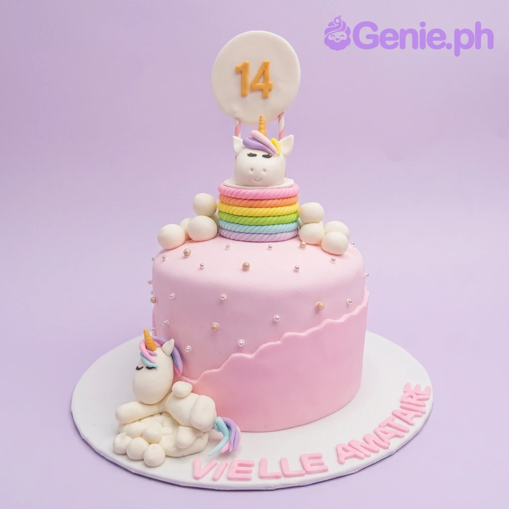 A pink and multi-colored fondant Unicorn cake, featuring a sleeping unicorn and number 14, with a rainbow border and clouds.