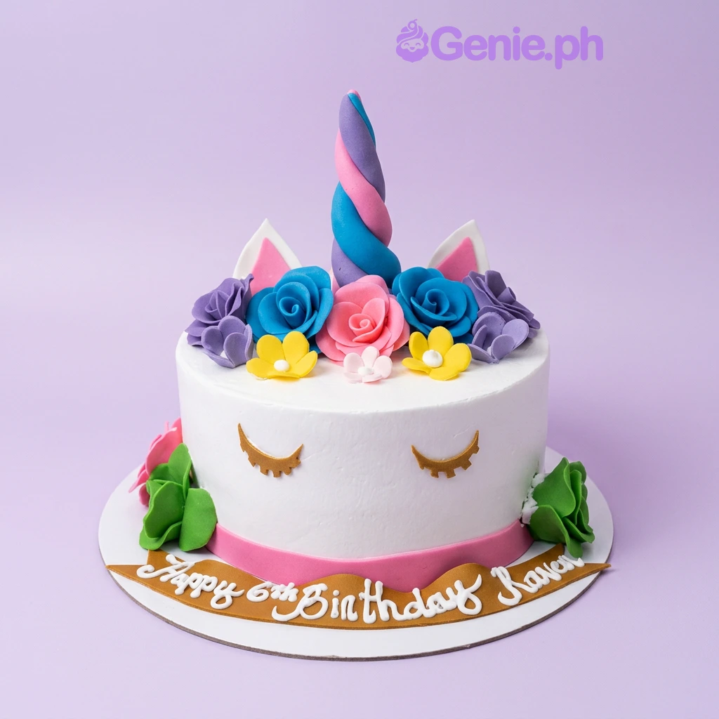 Unicorn White Floral Cake A white 1-tier cake themed around Unicorn, featuring a colorful twisted horn, fondant ears, various edible flowers, and gold eyelashes.