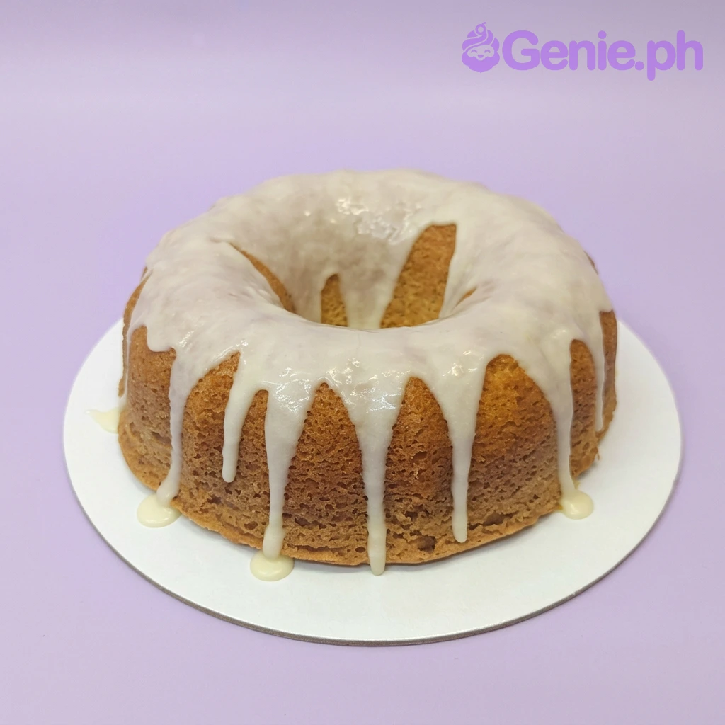 Vanilla Lemon Bundt White Cake A golden-brown and white 1 Tier Bundt cake, themed Vanilla Lemon Bundt, featuring a thick white glaze dripping down the sides.