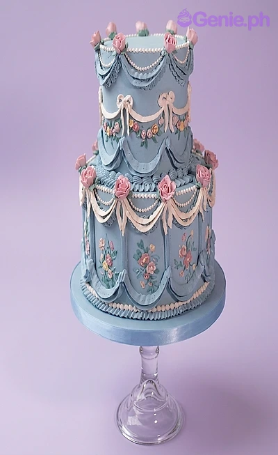 Vintage Blue Floral Sky Blue 2-Tier Cake A light blue and pink 2-tier fondant cake with a Vintage Blue Floral theme, featuring pink fondant roses and white icing details.