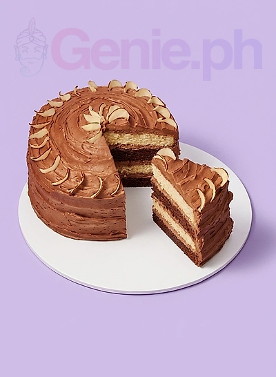 Vintage four-layer Regency Ribbon Cake with chocolate icing and cream-colored frosting accents on a floral plate.