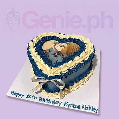 Heart-shaped blue and white vintage cake with a printed character image and a white ribbon bow.