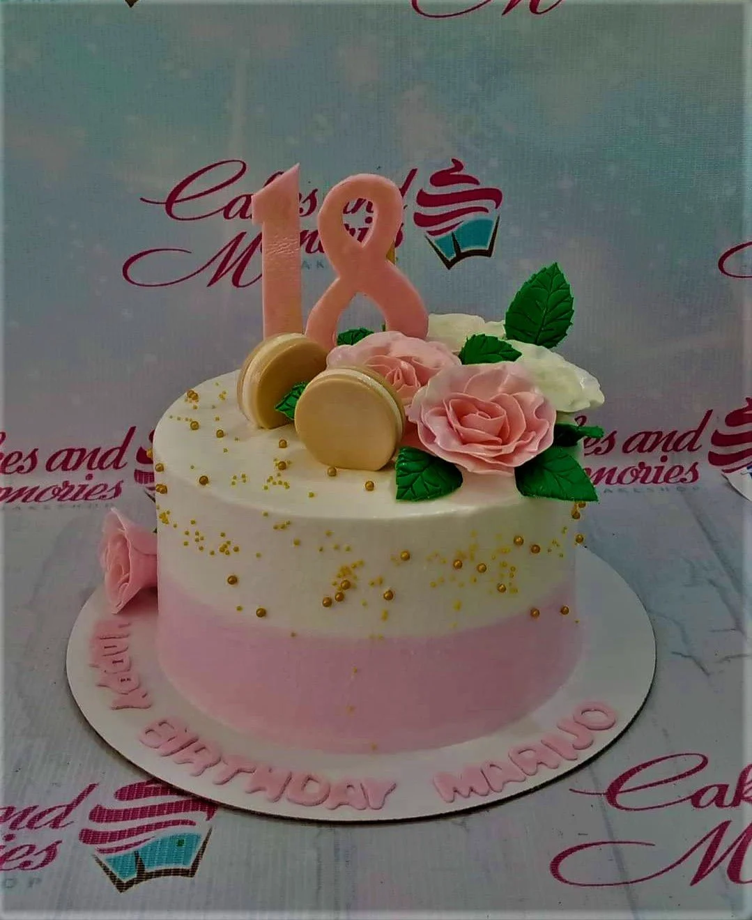 18th Birthday White Floral Cake A pink and white ombre 1-tier 18th birthday cake, featuring a pink number 18 topper, roses, macarons, and gold dragees.