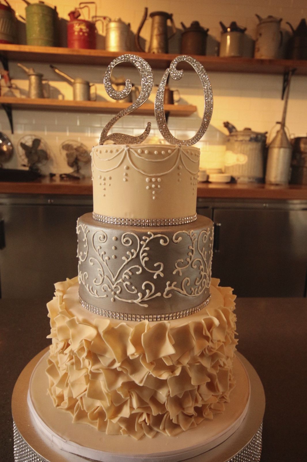 Elegant 3-tier silver and ivory fondant cake with intricate white piping, ruffles, and a rhinestone number 20 topper. Elegant 3-tier silver and ivory fondant cake with intricate white piping, ruffles, and a rhinestone number 20 topper.