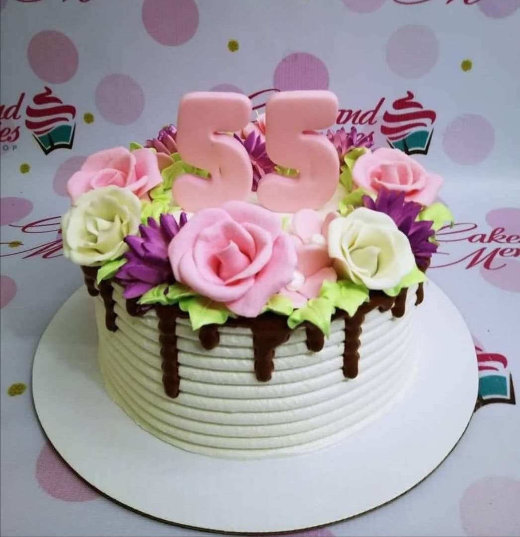 White textured icing cake with pink and white gumpaste roses, purple flowers, and a pink number 55 topper with chocolate drip. White textured icing cake with pink and white gumpaste roses, purple flowers, and a pink number 55 topper with chocolate drip.