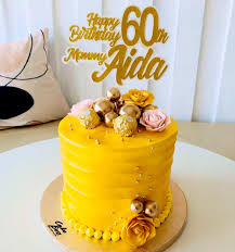 Yellow 1-tier birthday cake with gold spheres, Ferrero Rocher chocolates, and pink and yellow edible roses. Yellow 1-tier birthday cake with gold spheres, Ferrero Rocher chocolates, and pink and yellow edible roses.