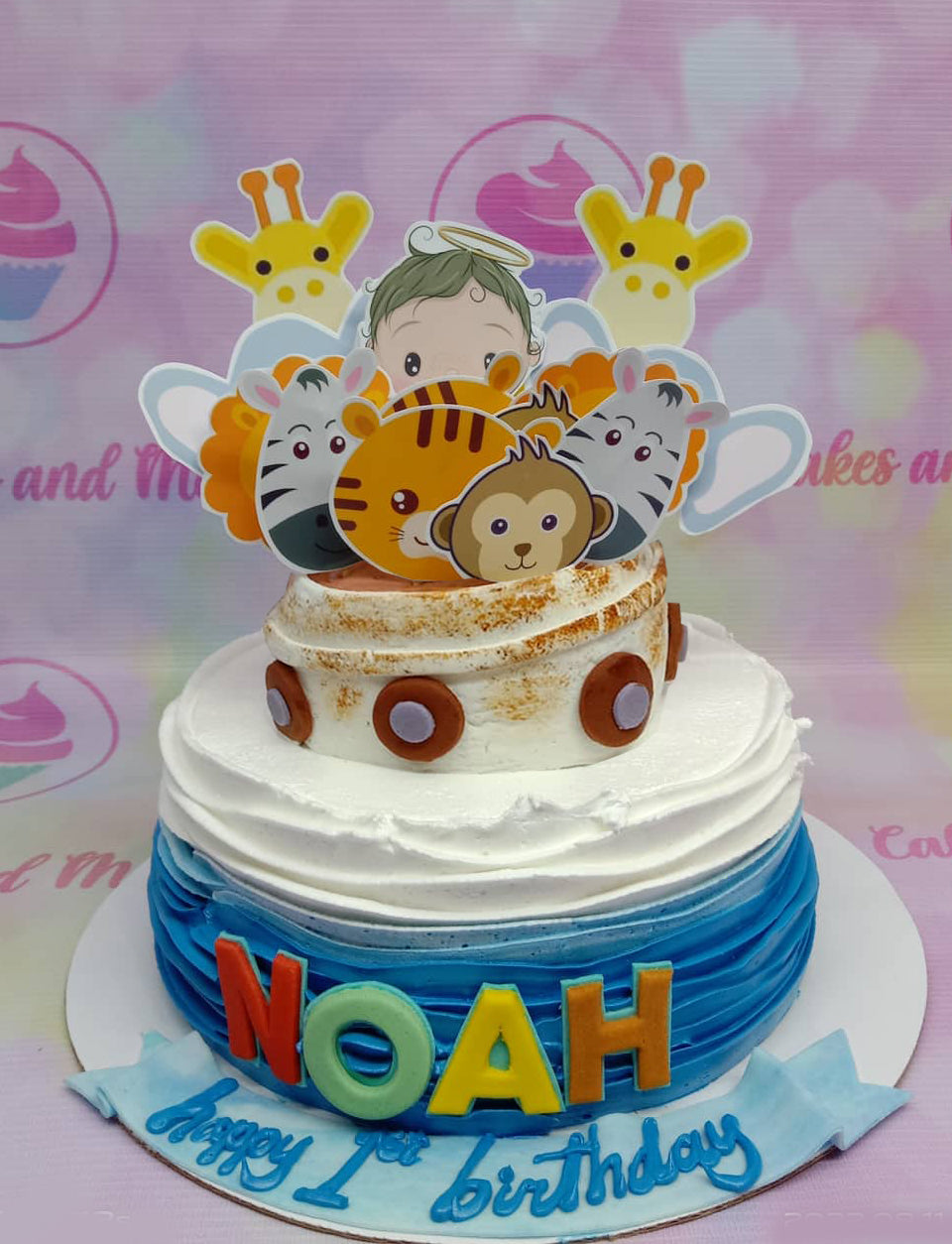 Noah's 1st birthday cake with a blue and white gradient icing, animal printouts, and a gumpaste name topper. Noah's 1st birthday cake with a blue and white gradient icing, animal printouts, and a gumpaste name topper.