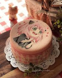 Pink bento cake featuring a hand-painted anime character Anya Forger from Spy x Family with a pink and white checkered side pattern.