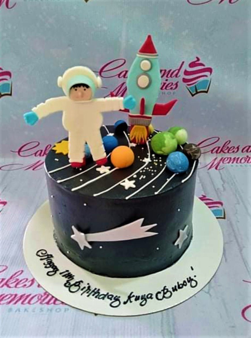 Black space themed cake with an astronaut, rocket, and planets fondant toppers. Black space themed cake with an astronaut, rocket, and planets fondant toppers.