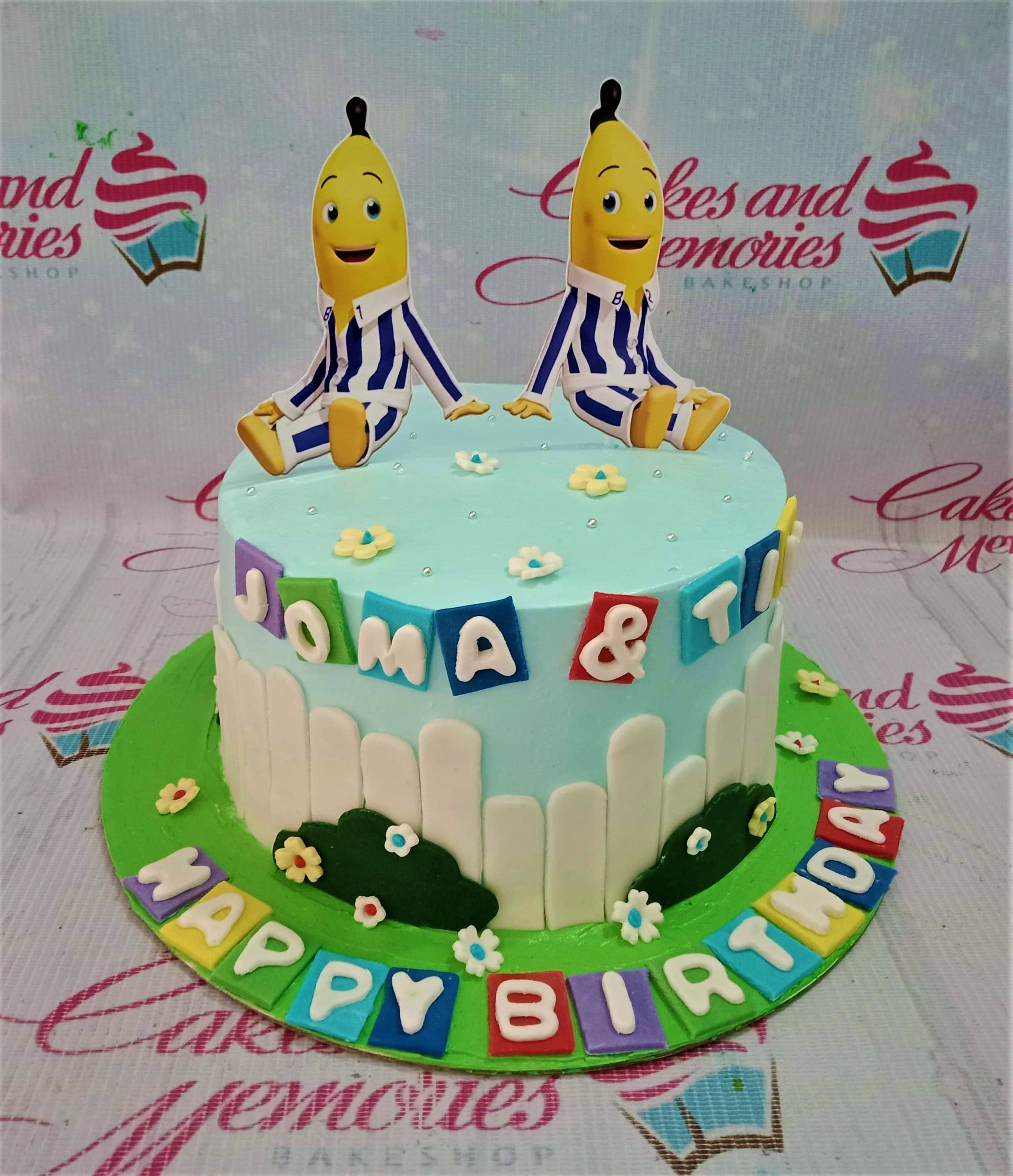 Light blue Bananas in Pyjamas themed birthday cake with white picket fence and colorful fondant letter blocks. Light blue Bananas in Pyjamas themed birthday cake with white picket fence and colorful fondant letter blocks.