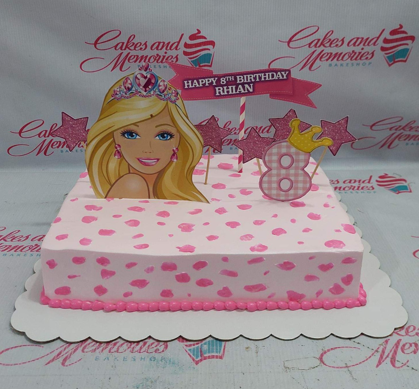Pink Barbie themed rectangle cake with pink icing spots, a large Barbie printout, glitter stars, and a pink number 8 topper. Pink Barbie themed rectangle cake with pink icing spots, a large Barbie printout, glitter stars, and a pink number 8 topper.