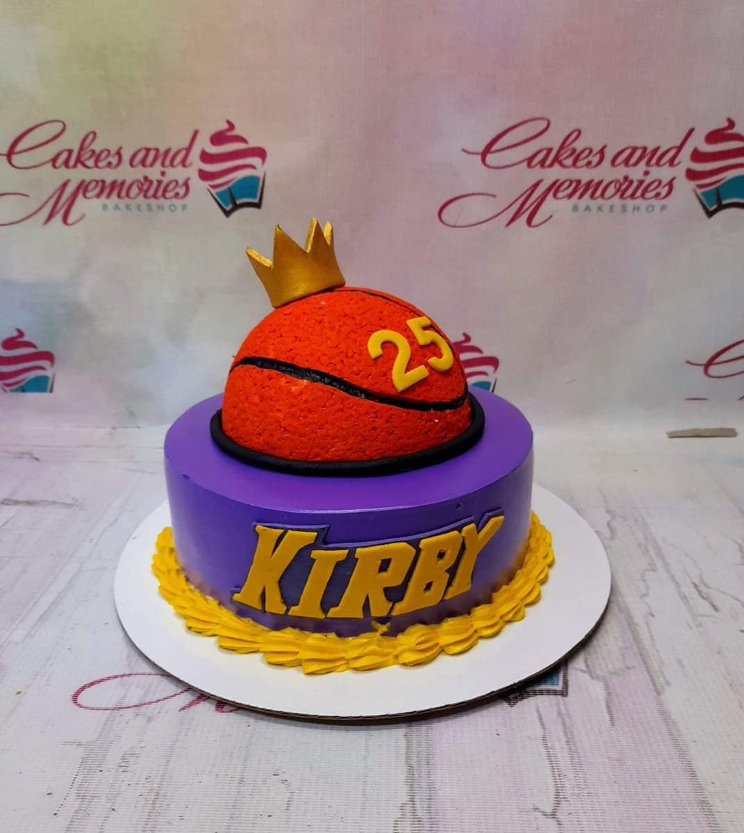 Purple basketball themed cake with a 3D basketball topper, gold crown, and yellow icing border. Purple basketball themed cake with a 3D basketball topper, gold crown, and yellow icing border.