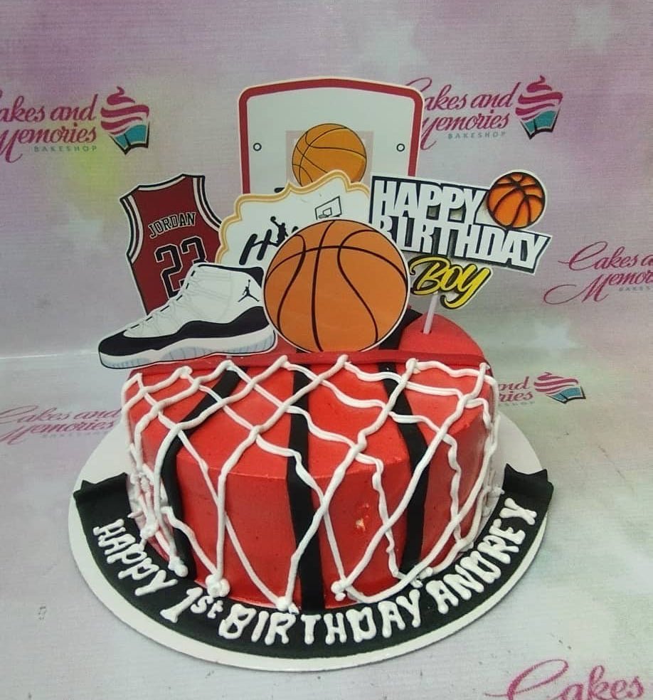Red and black basketball themed birthday cake with Jordan jersey, sneaker, and basketball hoop toppers for Andrey's 1st birthday. Red and black basketball themed birthday cake with Jordan jersey, sneaker, and basketball hoop toppers for Andrey's 1st birthday.