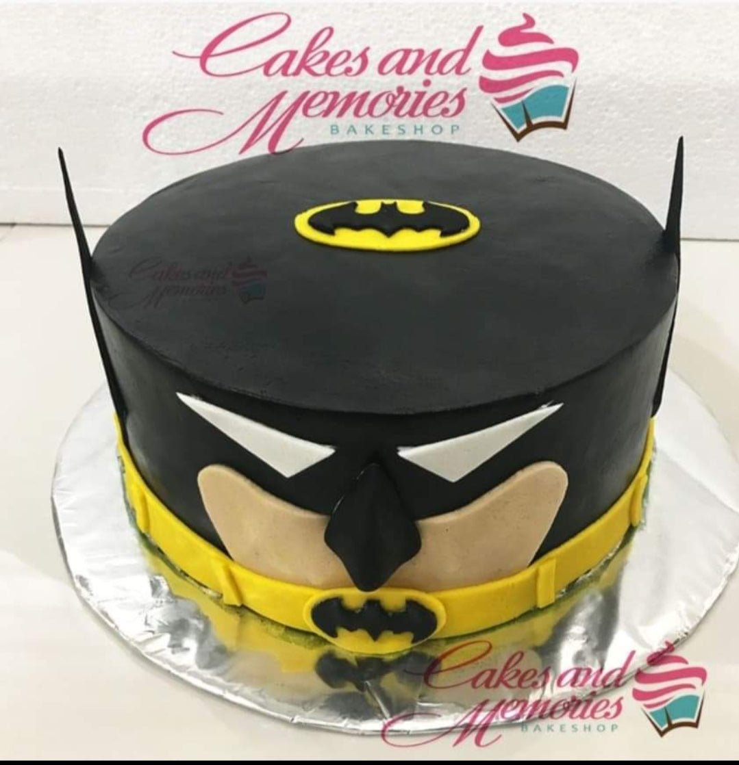 Batman themed black fondant cake with yellow utility belt and bat logo on top. Batman themed black fondant cake with yellow utility belt and bat logo on top.