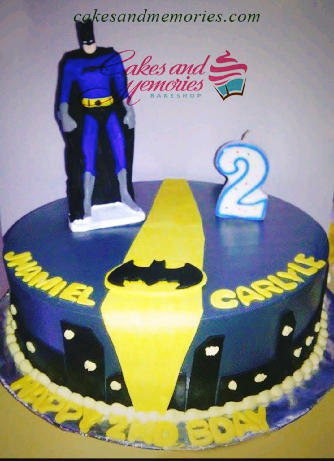 Batman themed birthday cake with a 3D Batman figure, yellow bat signal, and city skyline silhouette on blue fondant. Batman themed birthday cake with a 3D Batman figure, yellow bat signal, and city skyline silhouette on blue fondant.