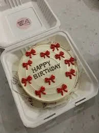 Birthday Red cake design — bento soft icing cake in white — with group of red bows, and custom "HAPPY BIRTHDAY" message