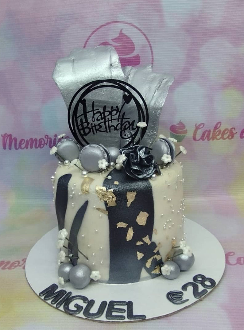 Elegant white and black 1-tier cake with silver macarons, a black rose, and silver gumpaste sails for a 28th birthday celebration. Elegant white and black 1-tier cake with silver macarons, a black rose, and silver gumpaste sails for a 28th birthday celebration.