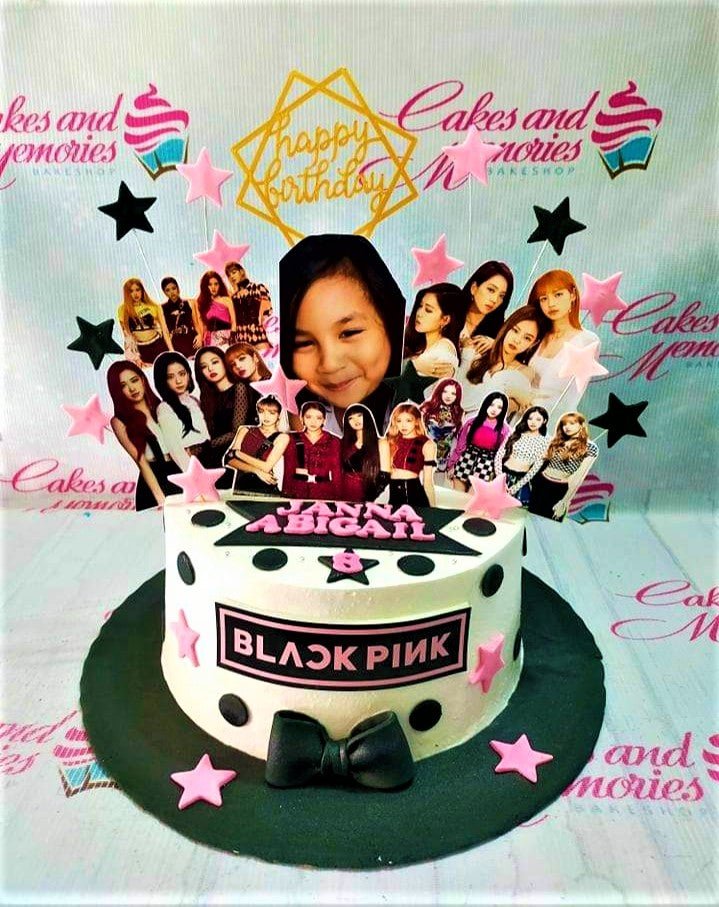 Blackpink themed birthday cake with photo printouts of the K-pop group and a young girl, decorated with pink and black stars and dots. Blackpink themed birthday cake with photo printouts of the K-pop group and a young girl, decorated with pink and black stars and dots.