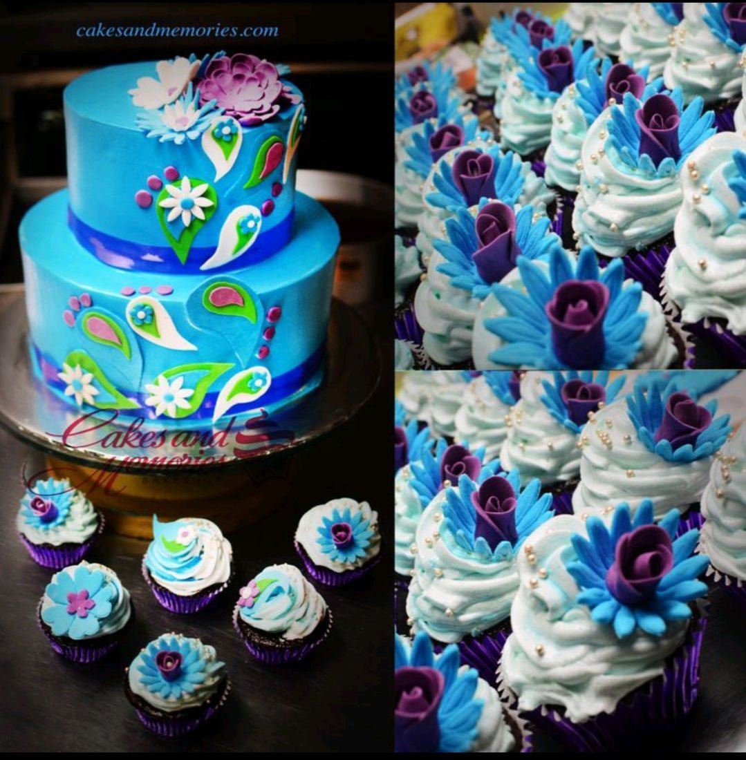 Two-tier blue cake with intricate purple and teal floral gumpaste designs and matching cupcakes. Two-tier blue cake with intricate purple and teal floral gumpaste designs and matching cupcakes.