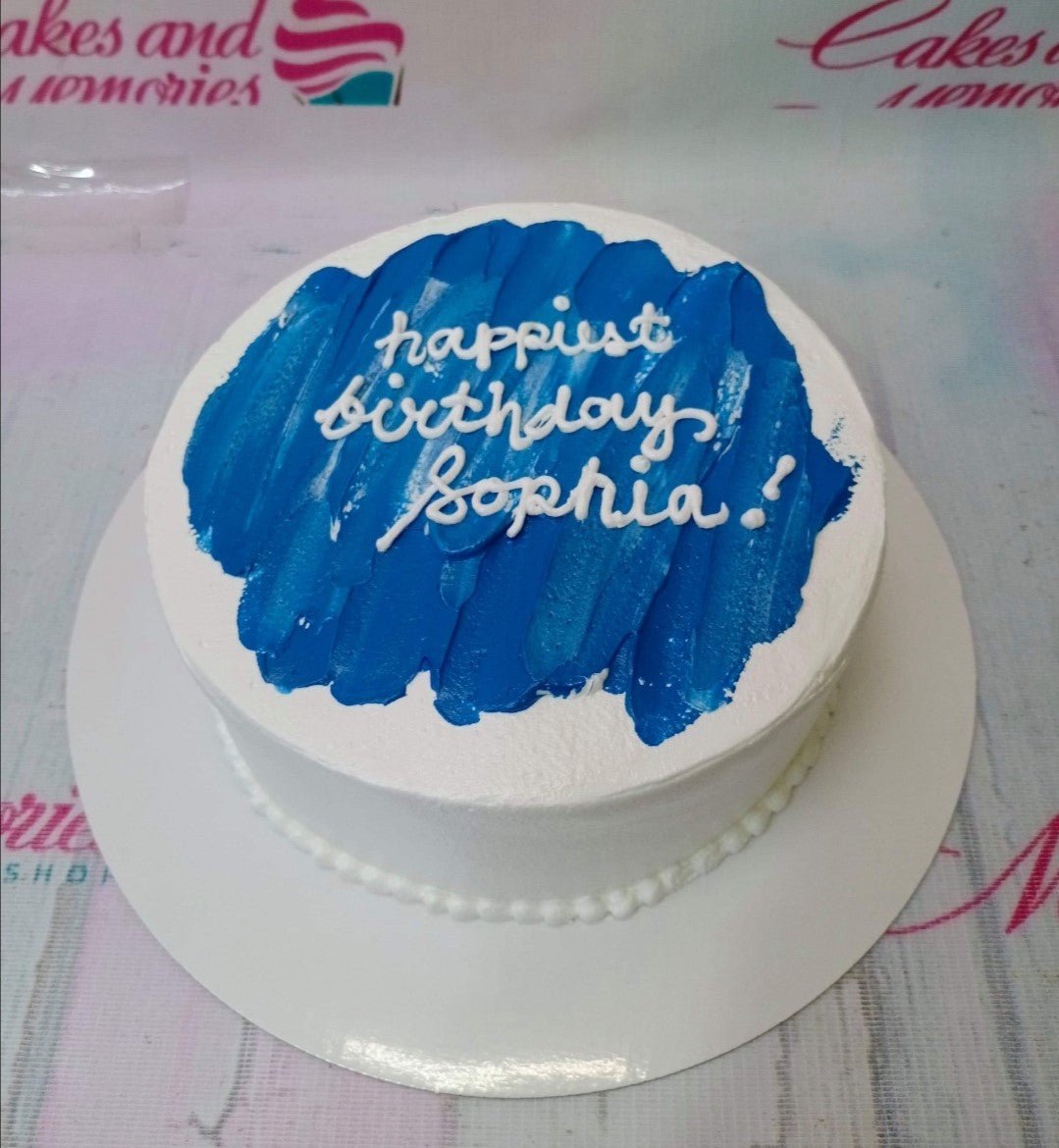 Minimalist white bento cake with a blue palette knife icing stroke and white piped birthday message. Minimalist white bento cake with a blue palette knife icing stroke and white piped birthday message.