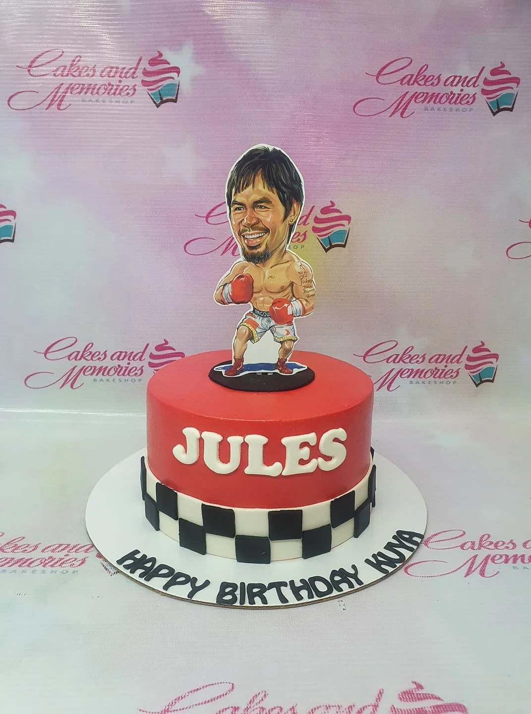 Red and white boxing themed cake featuring a Manny Pacquiao caricature printout and checkered racing pattern on the base.