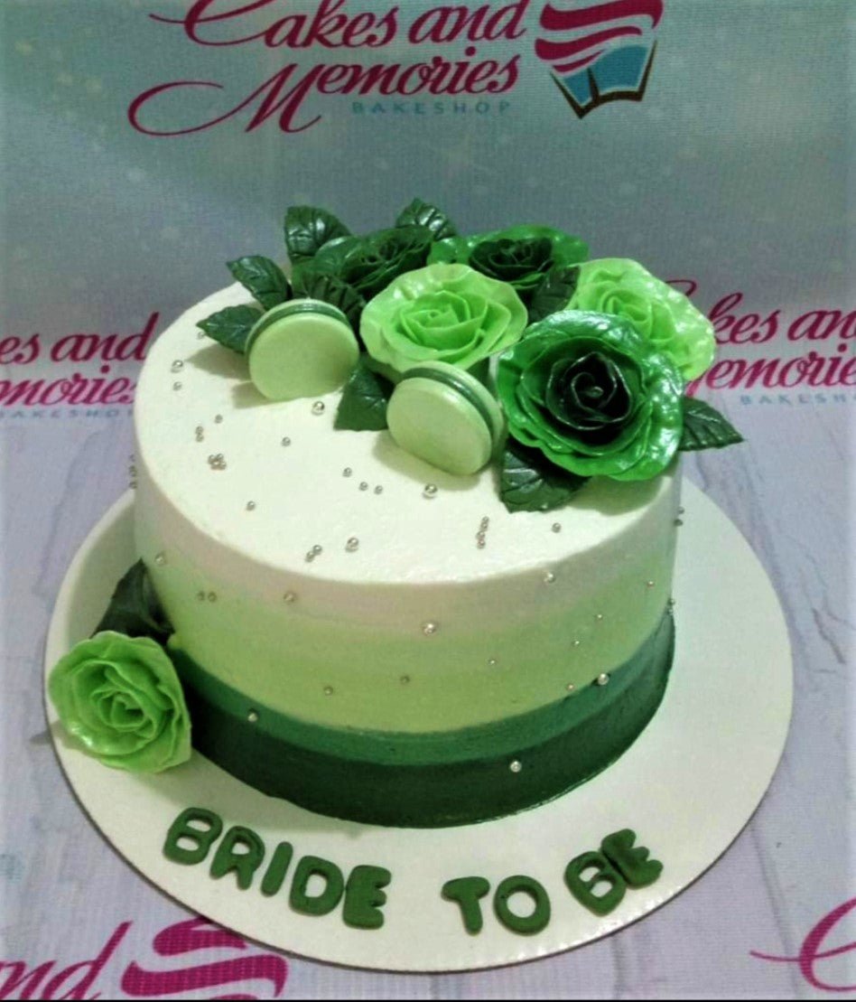 Single tier green ombre cake with green edible roses, macarons, and silver dragees for a bridal shower. Single tier green ombre cake with green edible roses, macarons, and silver dragees for a bridal shower.