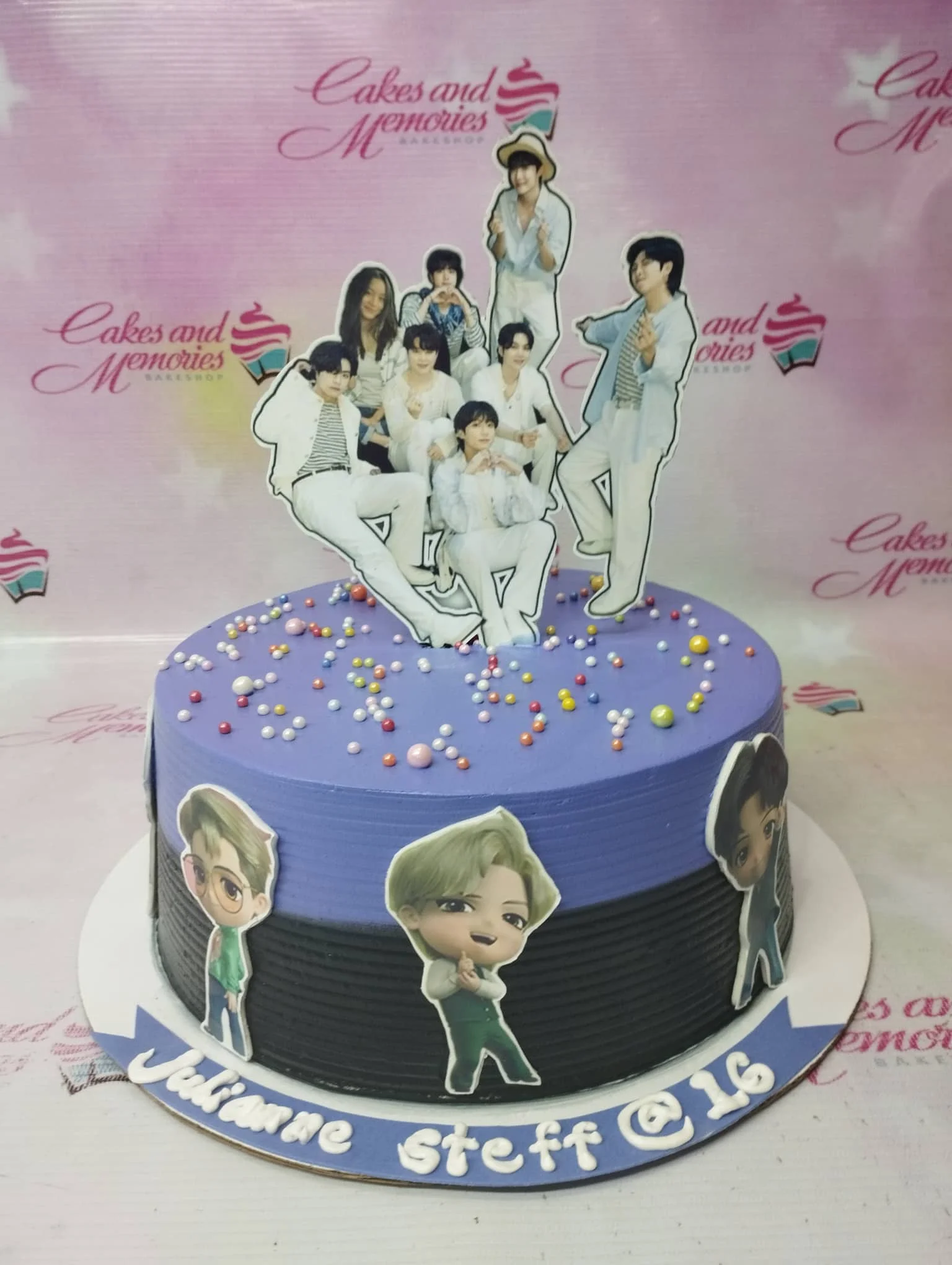 BTS K-pop themed birthday cake with purple and black icing, featuring member printouts and colorful sprinkles.