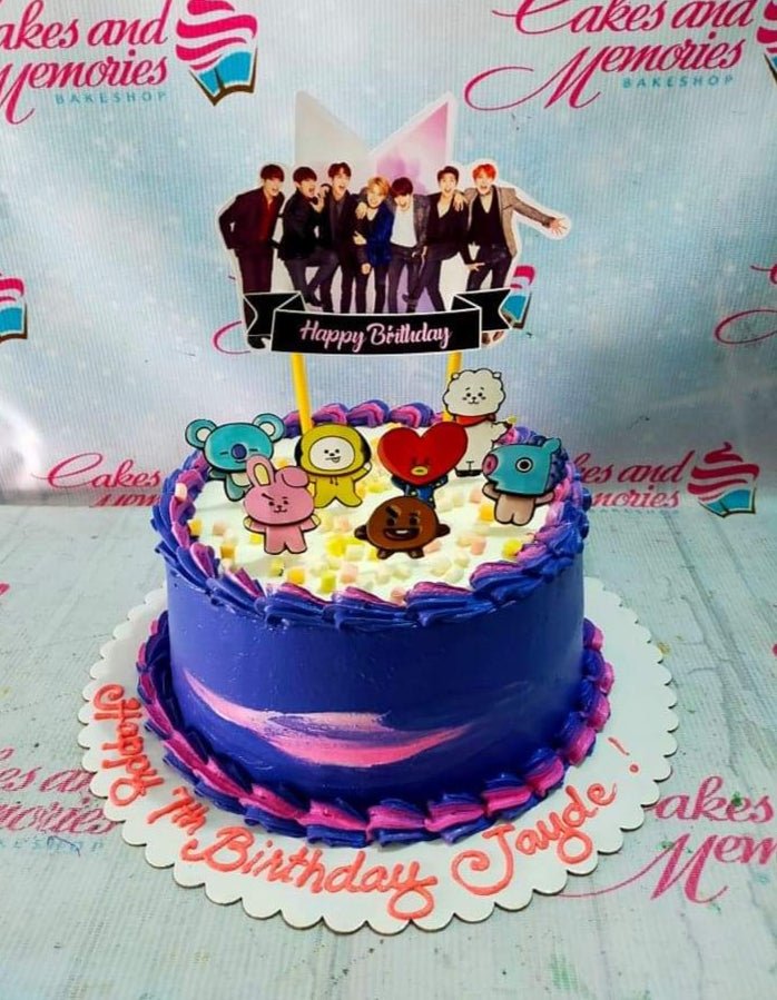 Purple BTS K-pop themed birthday cake with BT21 character toppers and a BTS group photo printout on top. Purple BTS K-pop themed birthday cake with BT21 character toppers and a BTS group photo printout on top.