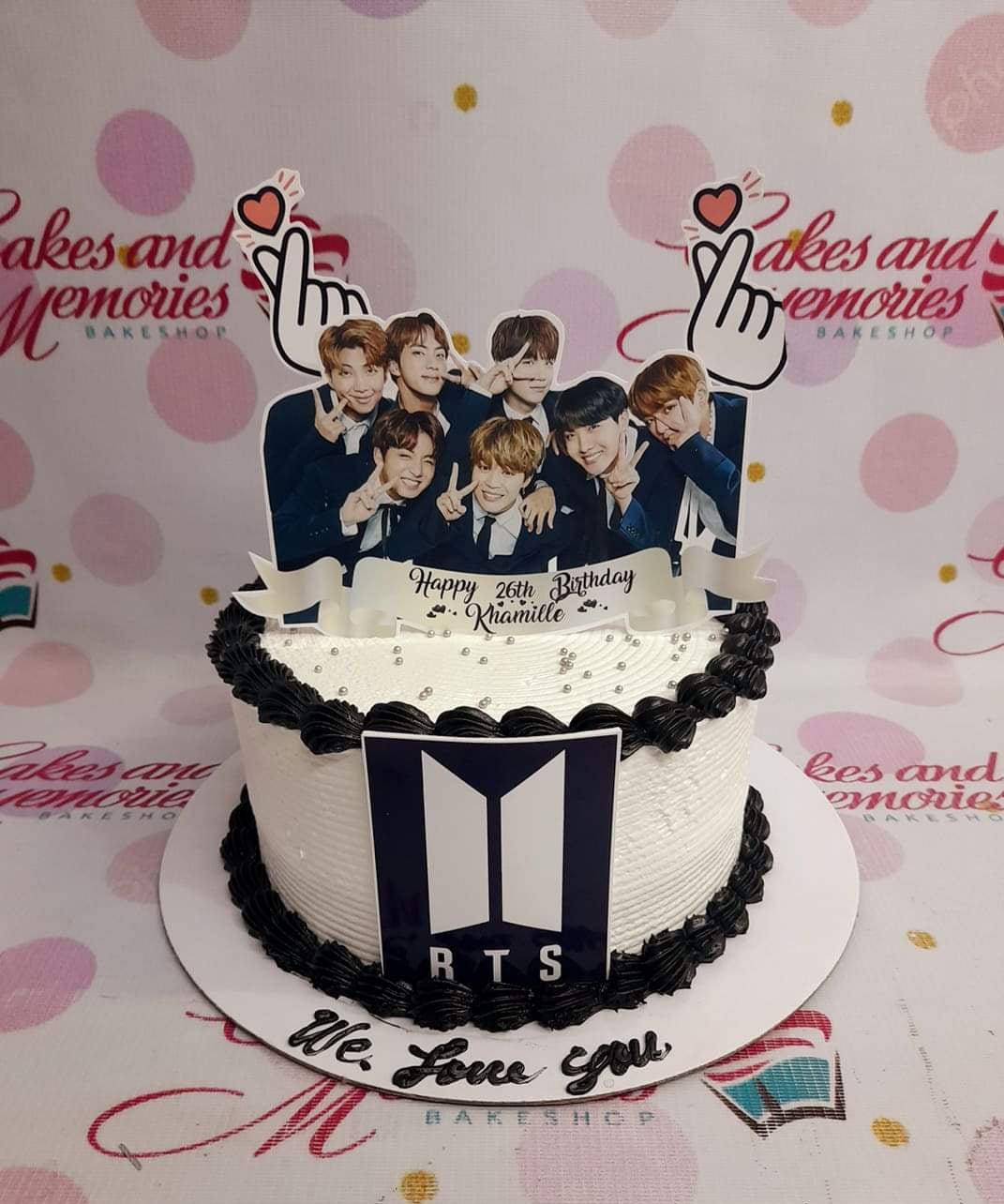 BTS K-pop themed birthday cake with black icing borders, silver dragees, and a large printout of the BTS members. BTS K-pop themed birthday cake with black icing borders, silver dragees, and a large printout of the BTS members.