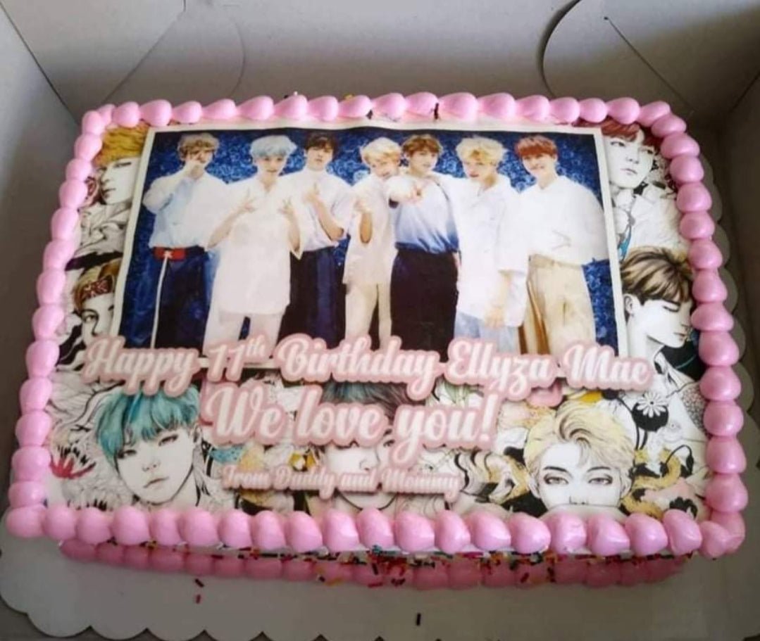Rectangle BTS K-pop themed birthday cake with pink icing borders and edible photo prints of the band members. Rectangle BTS K-pop themed birthday cake with pink icing borders and edible photo prints of the band members.