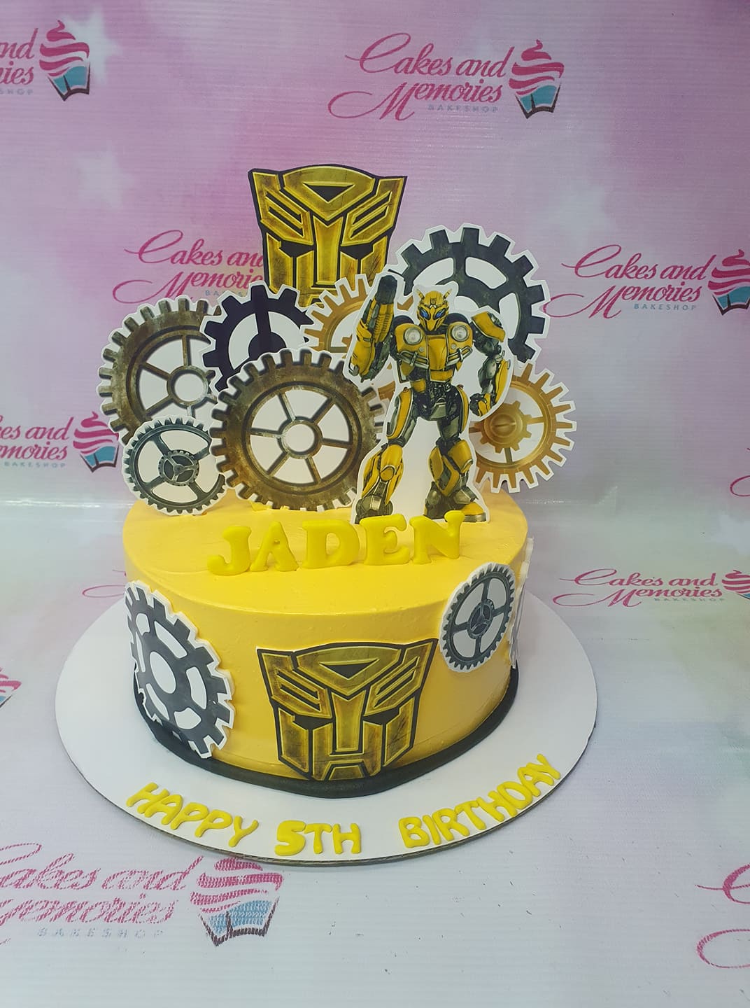 Yellow Bumblebee Transformers birthday cake with gear printouts and gumpaste letters Yellow Bumblebee Transformers birthday cake with gear printouts and gumpaste letters