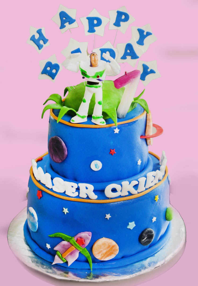Two-tier blue Buzz Lightyear space themed birthday cake with fondant planets, stars, and a rocket ship. Two-tier blue Buzz Lightyear space themed birthday cake with fondant planets, stars, and a rocket ship.