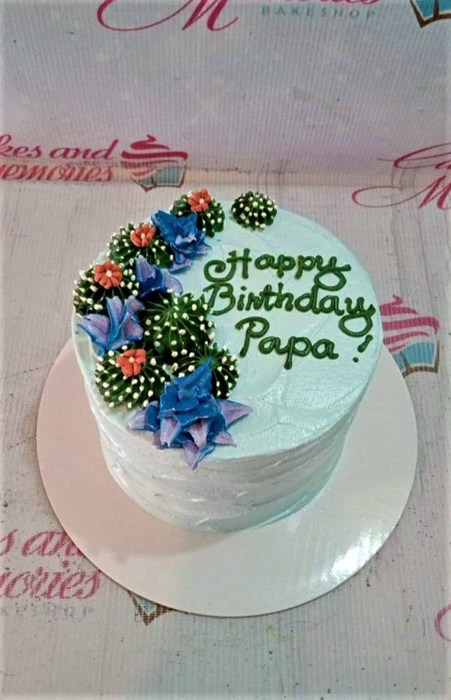 Light blue birthday cake for Papa featuring green piped icing cacti and blue succulent decorations with a Happy Birthday message. Light blue birthday cake for Papa featuring green piped icing cacti and blue succulent decorations with a Happy Birthday message.