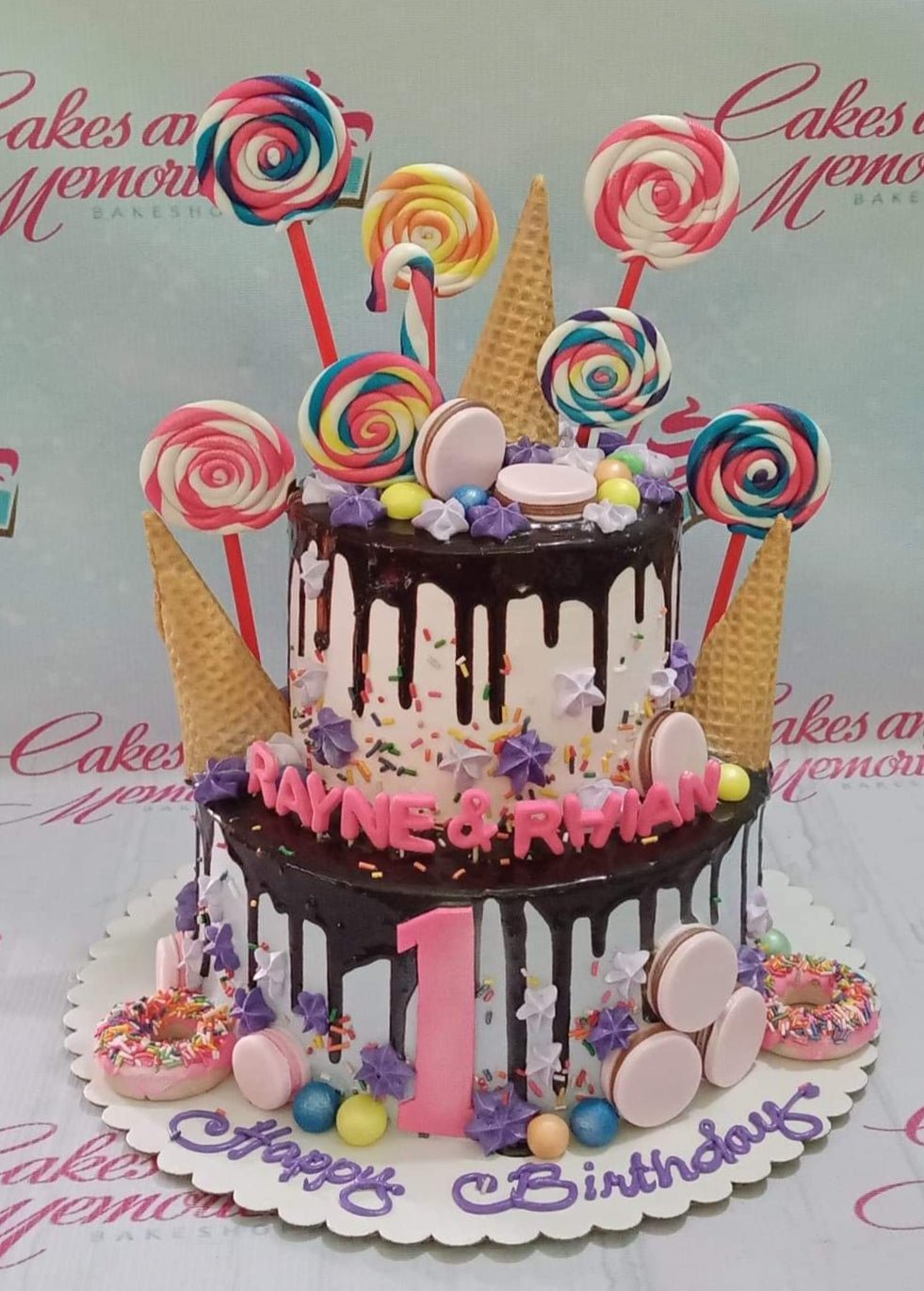 Colorful 2-tier candy themed birthday cake with chocolate drip, lollipops, donuts, and macarons. Colorful 2-tier candy themed birthday cake with chocolate drip, lollipops, donuts, and macarons.