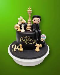 Black fondant chess themed birthday cake for Dan with gold chess pieces and a 3D male figurine. Black fondant chess themed birthday cake for Dan with gold chess pieces and a 3D male figurine.