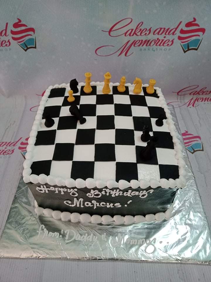 Square chess board cake with black and white fondant squares and 3D edible chess pieces on top. Square chess board cake with black and white fondant squares and 3D edible chess pieces on top.