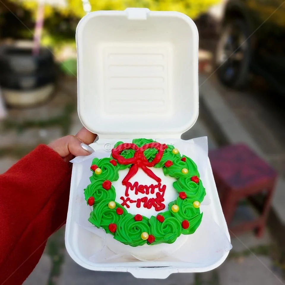 Bento cake with a green icing Christmas wreath design, red bow, and 'Merry X-mas' message in red icing. Bento cake with a green icing Christmas wreath design, red bow, and 'Merry X-mas' message in red icing.
