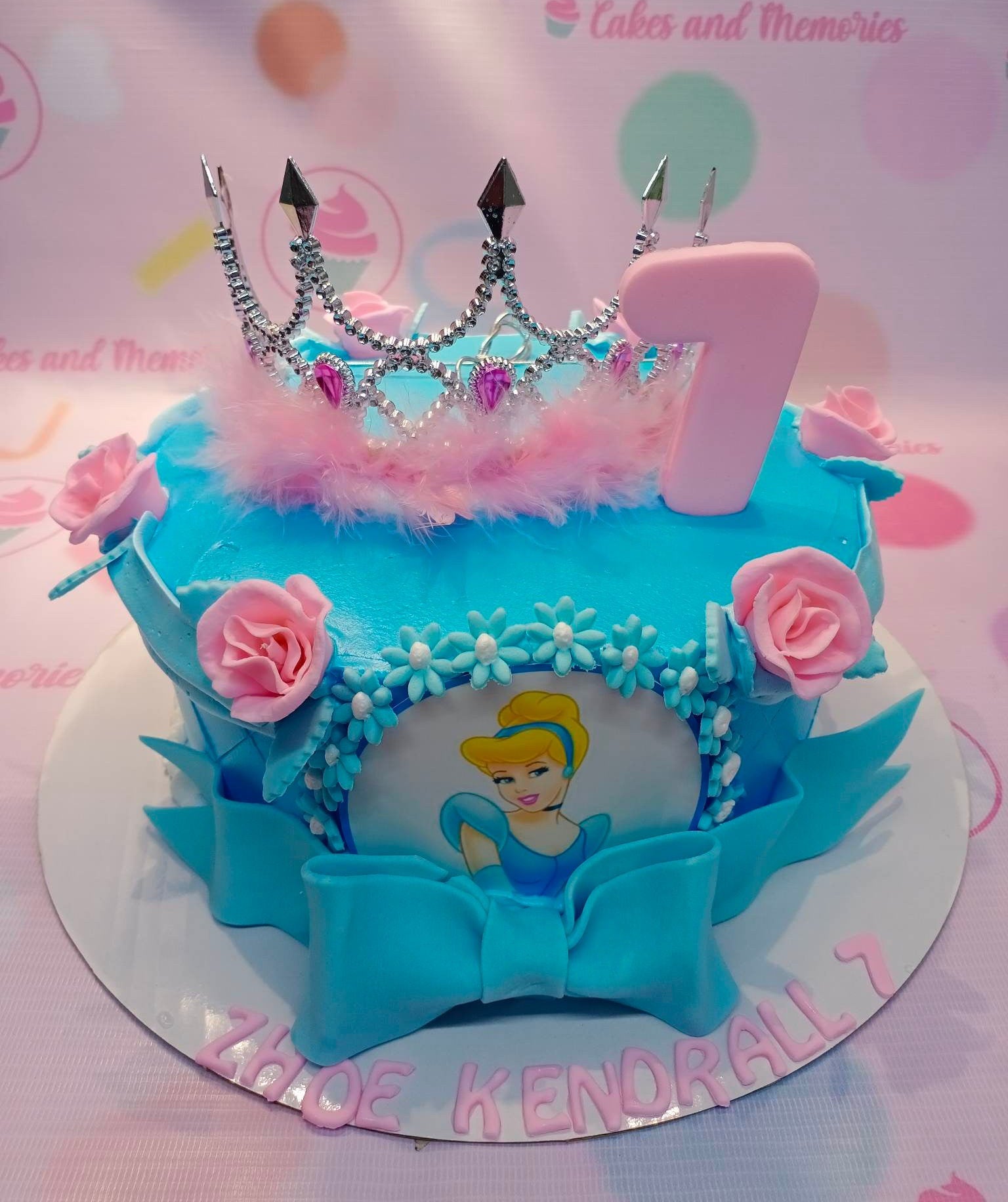 Blue Cinderella themed birthday cake with a silver rhinestone tiara, pink fondant roses, and a large blue fondant bow. Blue Cinderella themed birthday cake with a silver rhinestone tiara, pink fondant roses, and a large blue fondant bow.