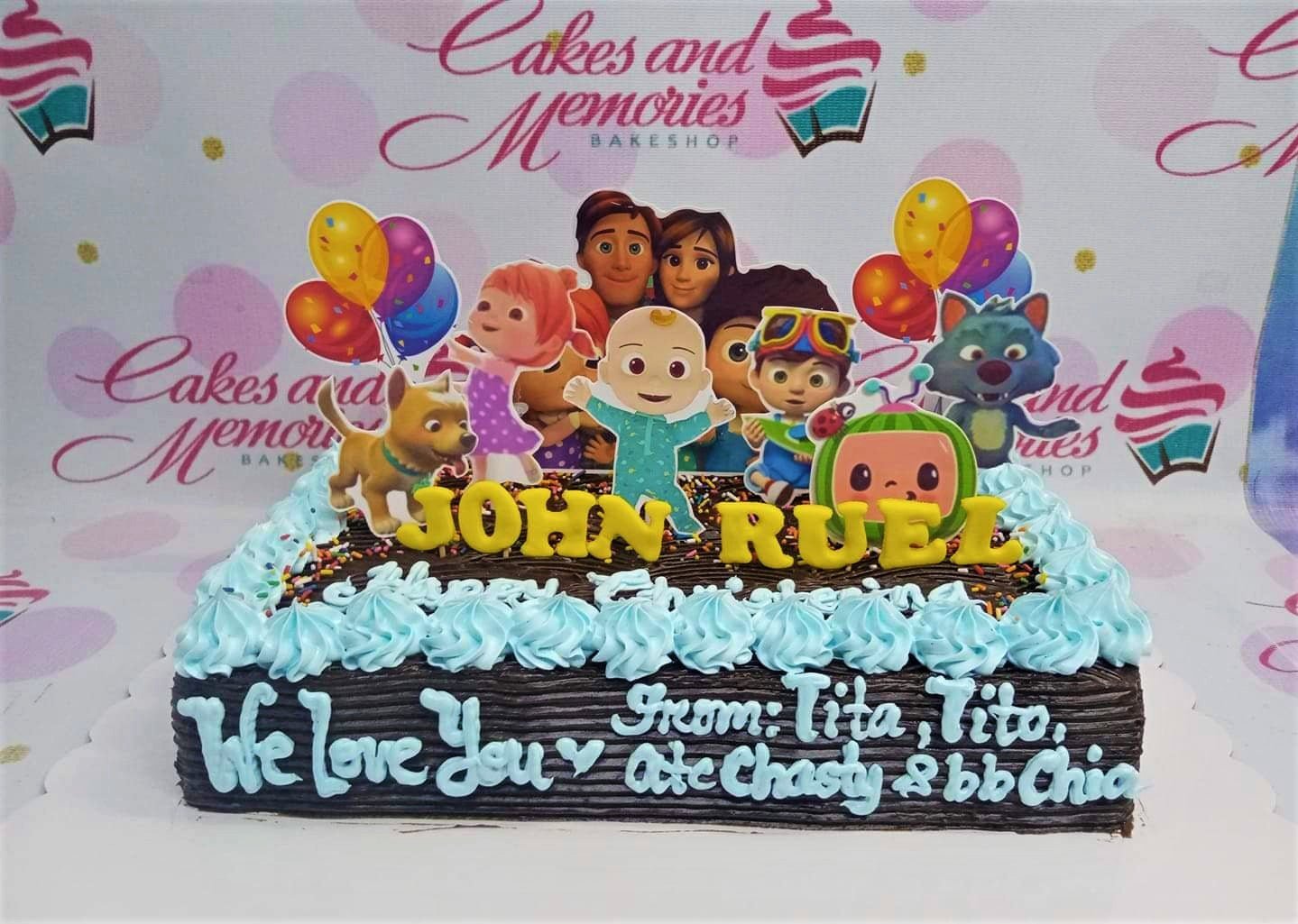 Cocomelon themed chocolate rectangle cake with blue icing rosettes and character printouts Cocomelon themed chocolate rectangle cake with blue icing rosettes and character printouts