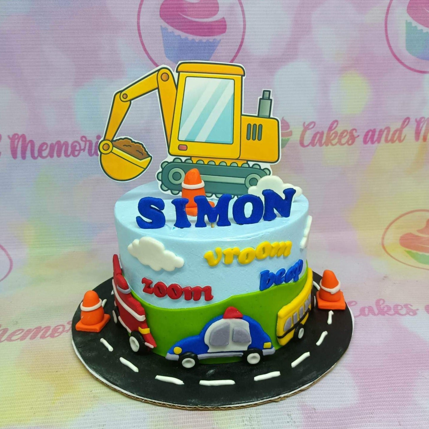 Light blue construction themed birthday cake with a large yellow excavator topper and colorful fondant vehicles around the base. Light blue construction themed birthday cake with a large yellow excavator topper and colorful fondant vehicles around the base.