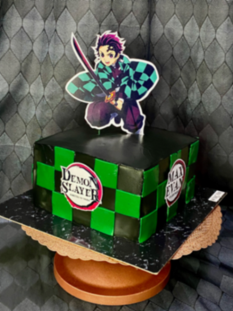 Square Demon Slayer themed cake with green and black checkered pattern and Tanjiro Kamado character topper. Square Demon Slayer themed cake with green and black checkered pattern and Tanjiro Kamado character topper.