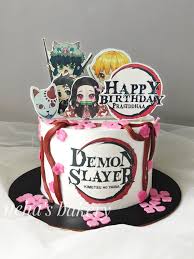 A white 1 tier cake featuring Demon Slayer characters, a 'Happy Birthday' banner, the Demon Slayer logo, red icing vines, and pink fondant flowers. A white 1 tier cake featuring Demon Slayer characters, a 'Happy Birthday' banner, the Demon Slayer logo, red icing vines, and pink fondant flowers.