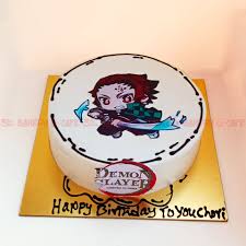 A white 1 tier cake featuring a printout of Tanjiro Kamado, the Demon Slayer logo, and black icing decorations. A white 1 tier cake featuring a printout of Tanjiro Kamado, the Demon Slayer logo, and black icing decorations.