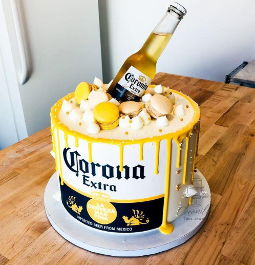 White 1-tier cake with yellow drip, Corona beer bottle topper, and yellow macarons